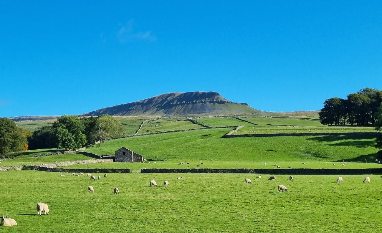 A mountain in sunshine with bright blue skies above